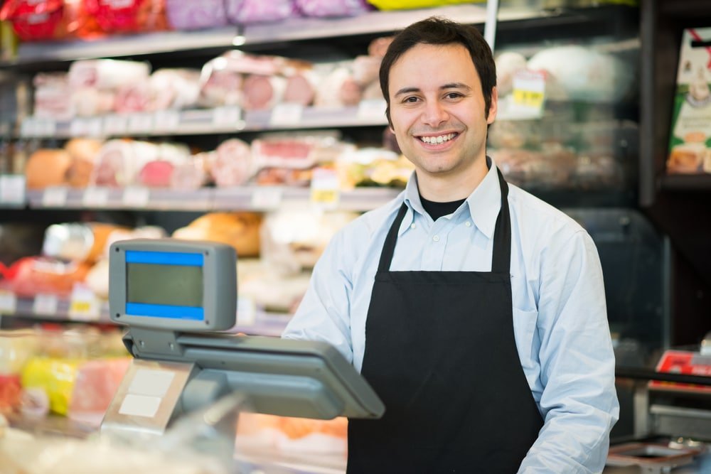 Portrait,Of,A,Smiling,Shopkeeper,In,A,Grocery,Store